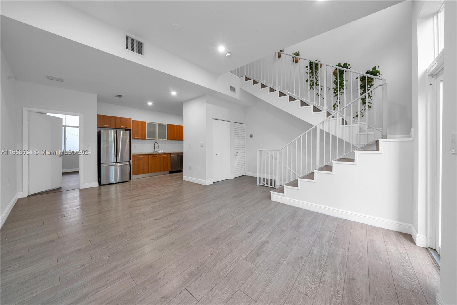 a view of a hallway with wooden floor and staircase