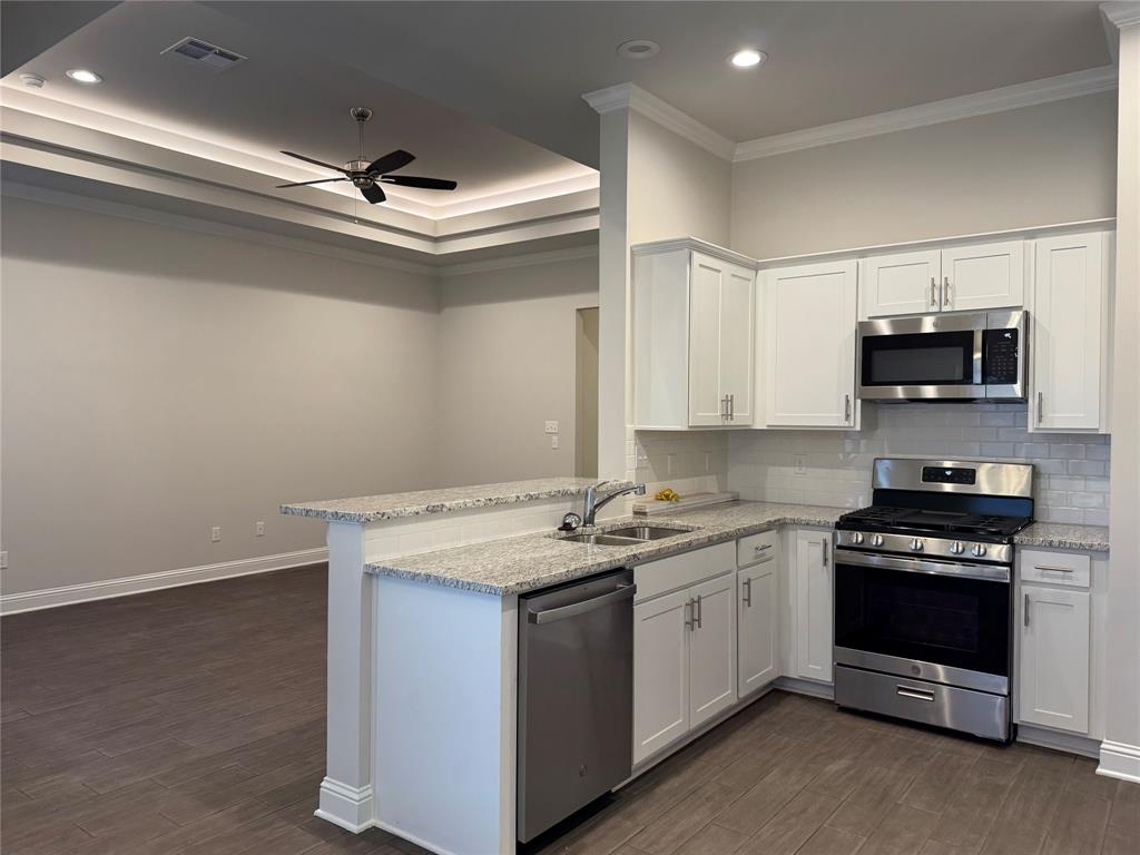 a kitchen with stainless steel appliances a stove a sink and a microwave