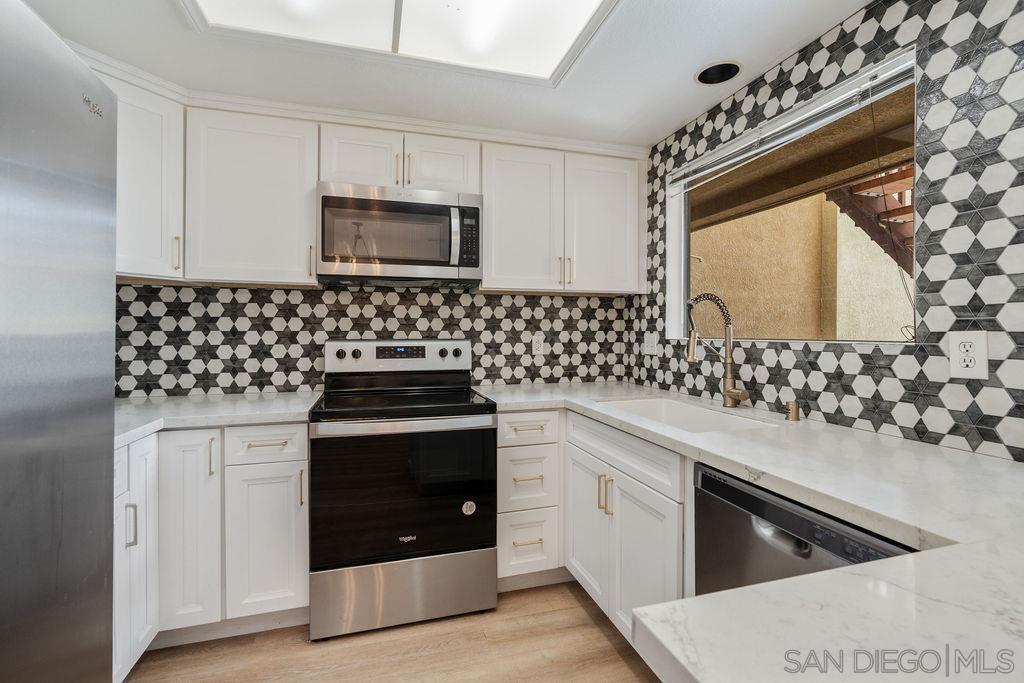 a kitchen with granite countertop a stove and a microwave