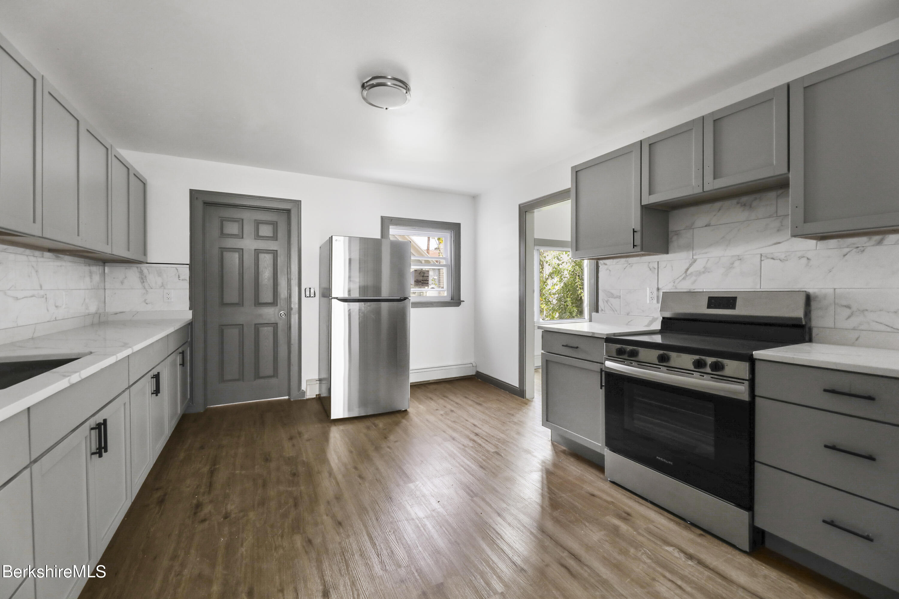 a kitchen with wooden floors and appliances