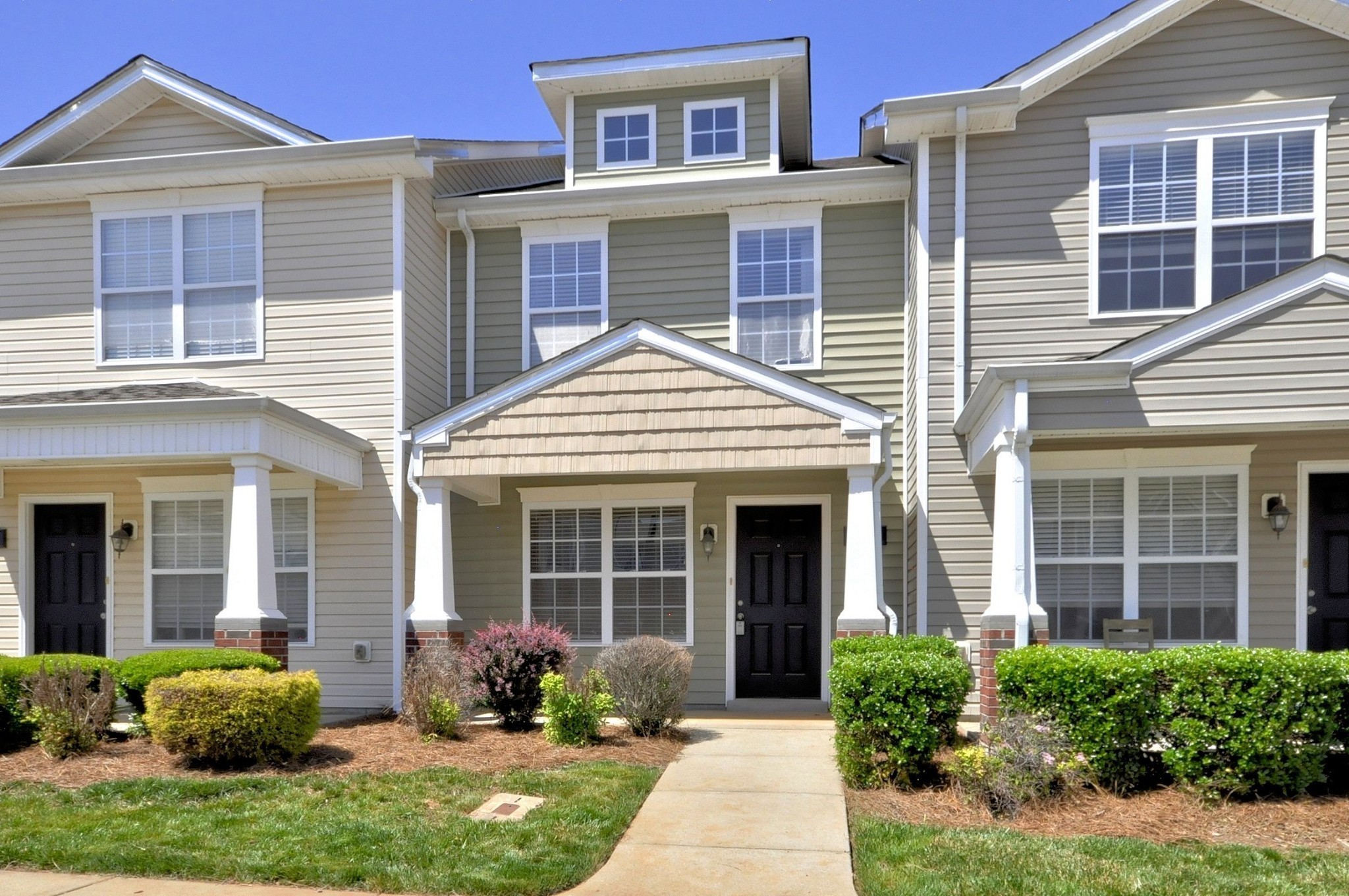 a front view of a house with a yard and outdoor seating