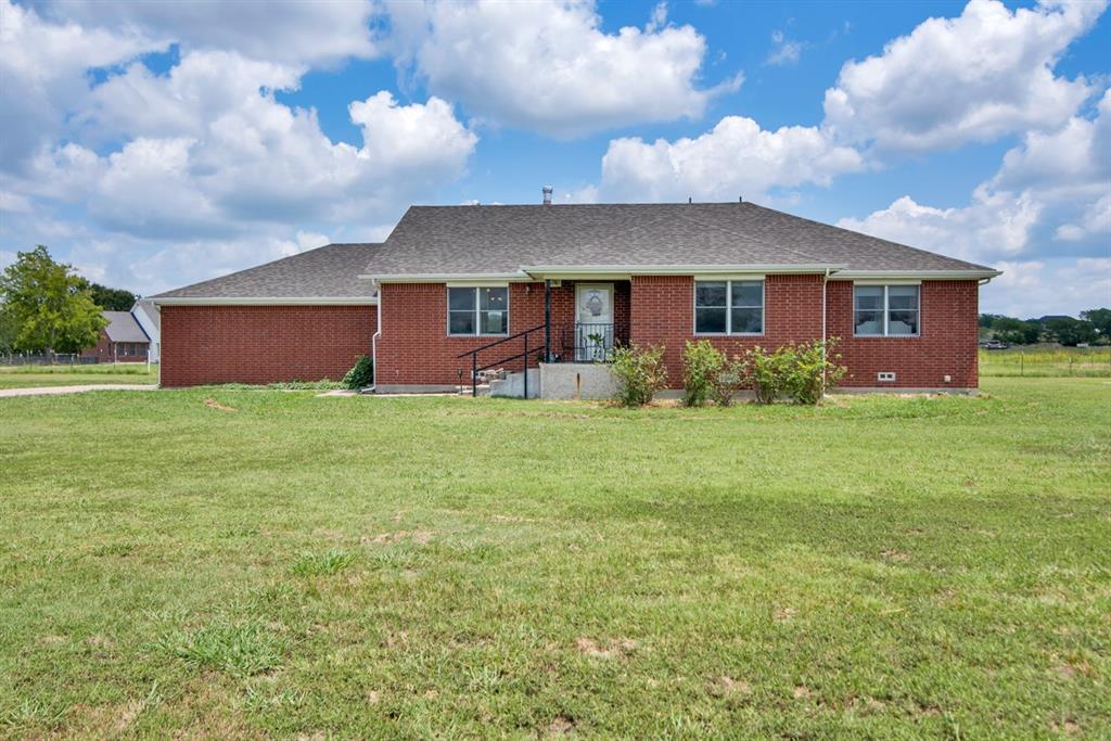 a front view of house with yard and green space