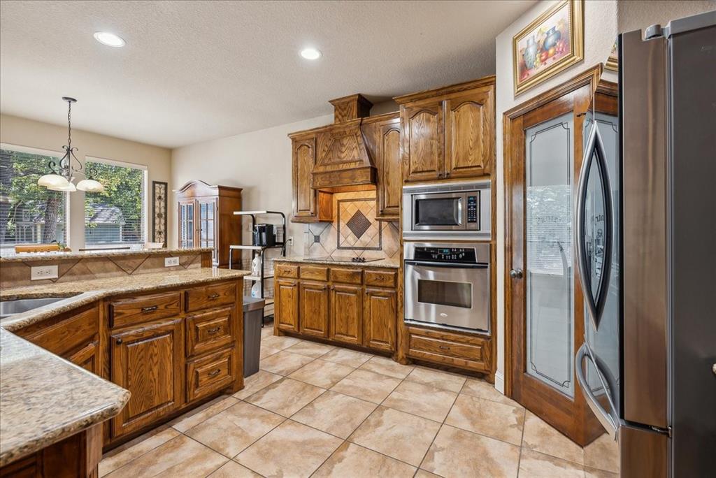 a kitchen with stainless steel appliances granite countertop a refrigerator and a sink