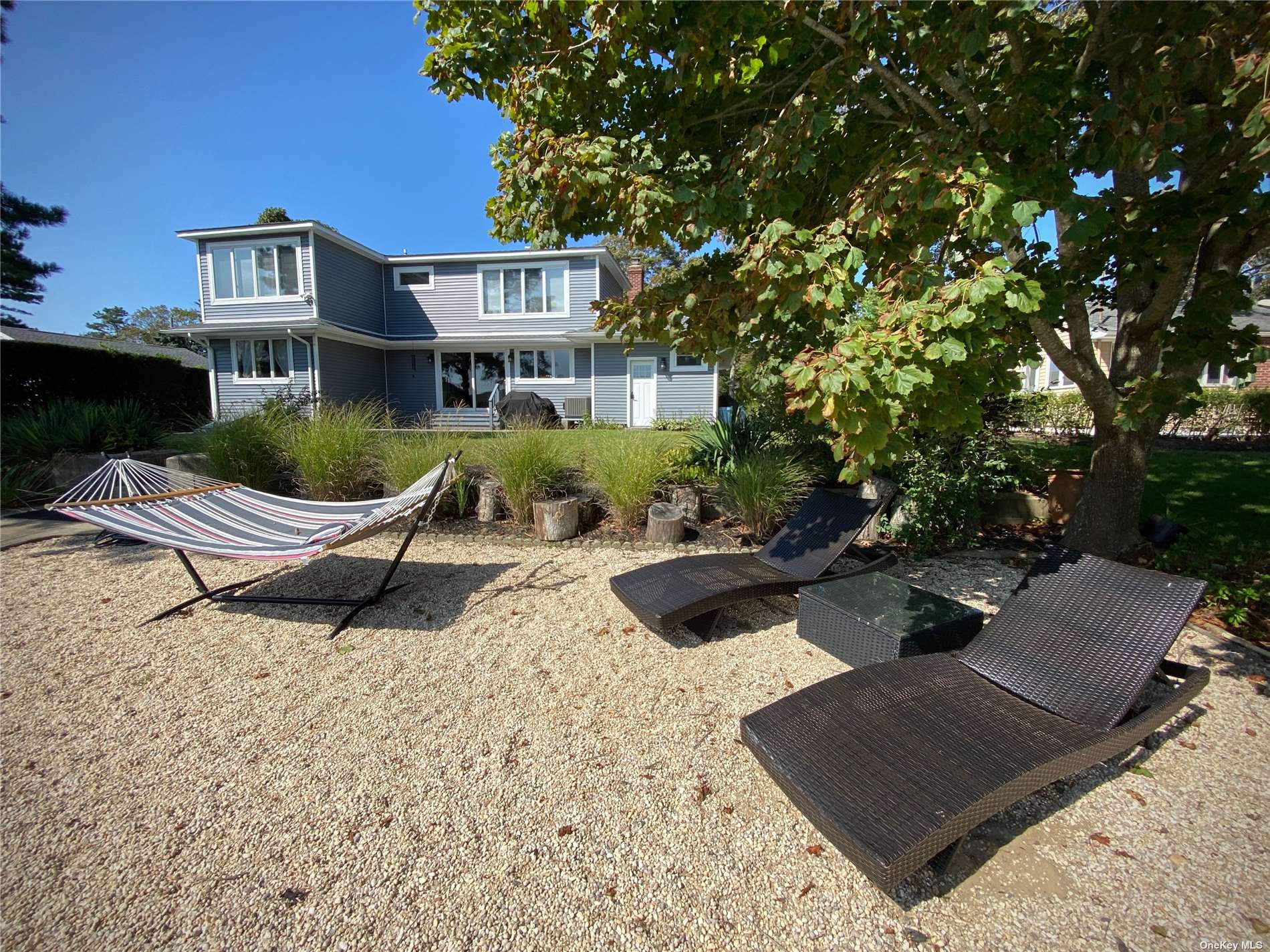 a view of a house with backyard and sitting area