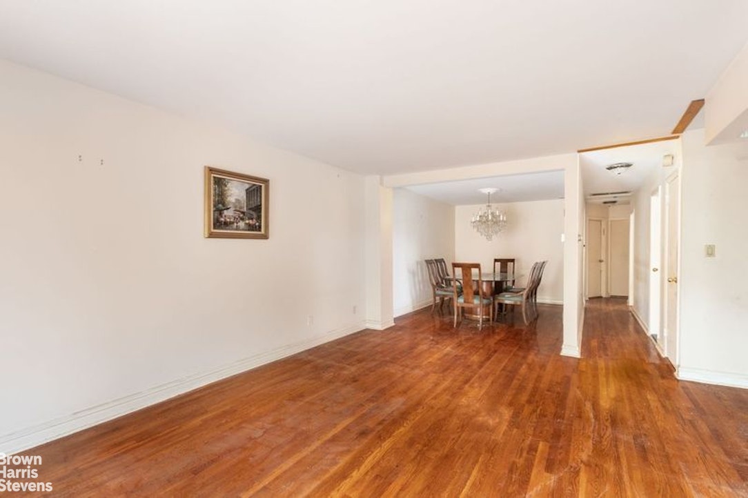 a view of a room with wooden floor and a bathroom