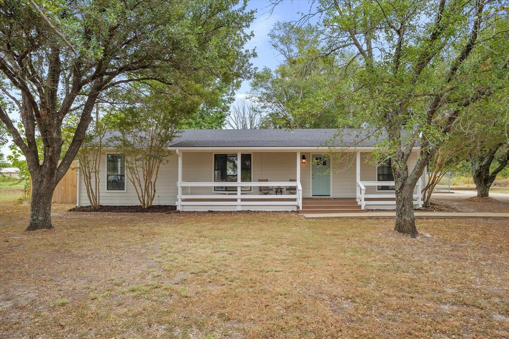 a view of a house with a large tree and a yard