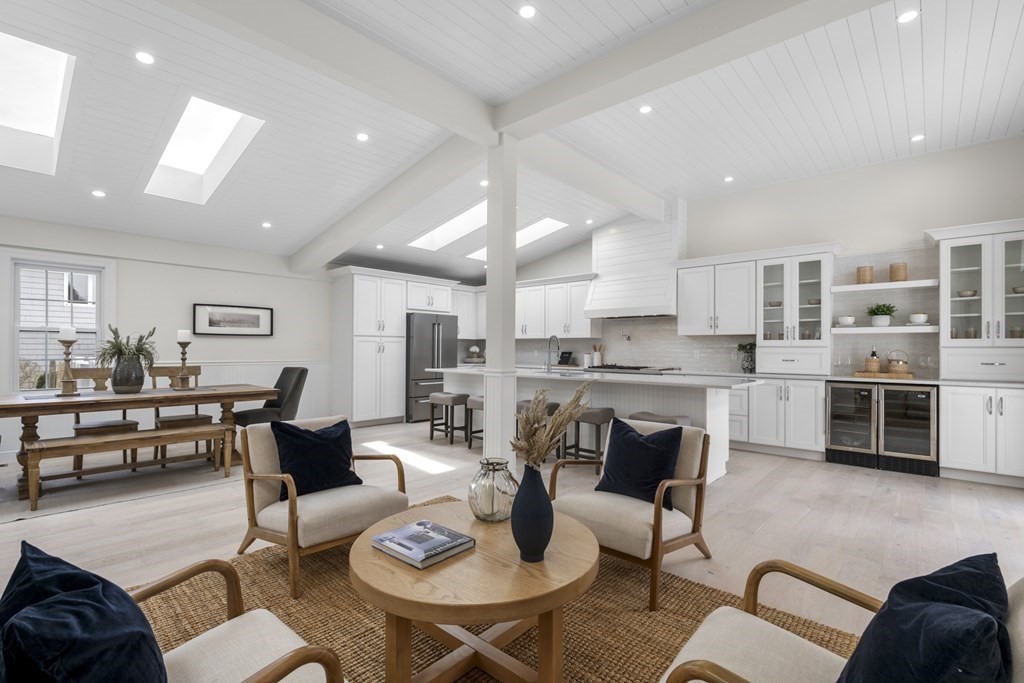 a living room with fireplace furniture and a view of kitchen