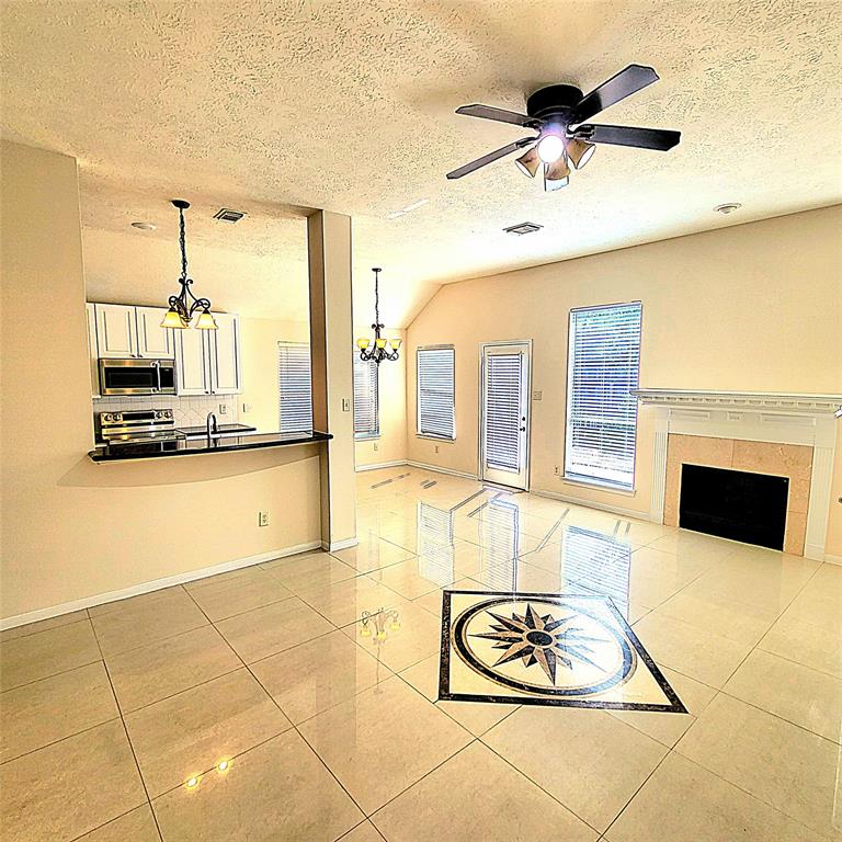 a living room with granite countertop furniture a fireplace and a flat screen tv