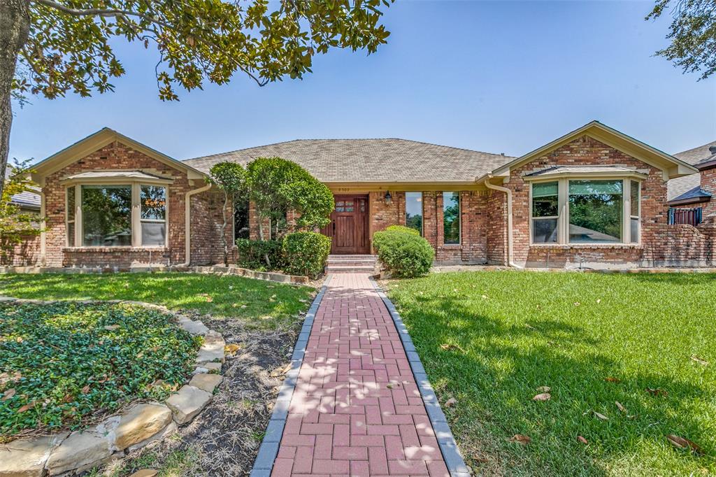 front view of a brick house with a yard