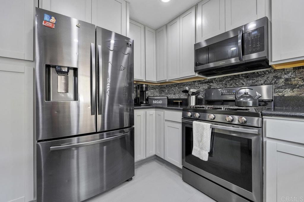 a metallic refrigerator freezer sitting in a kitchen