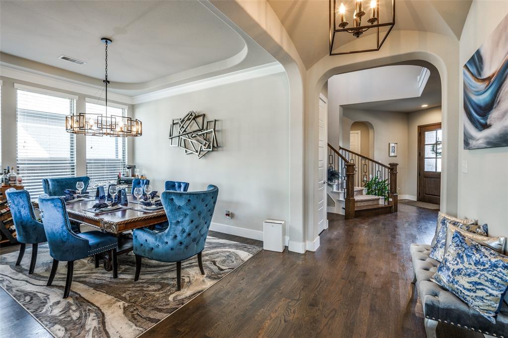 a dining room with furniture a chandelier and wooden floor