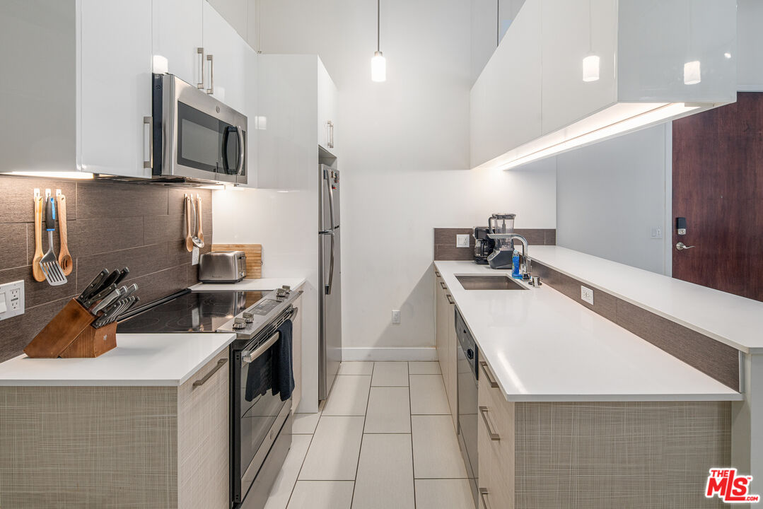 a kitchen with stainless steel appliances a sink stove and refrigerator