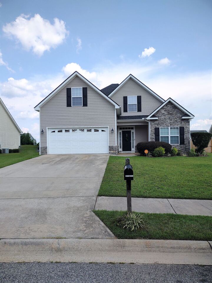 a front view of a house with a yard and garage