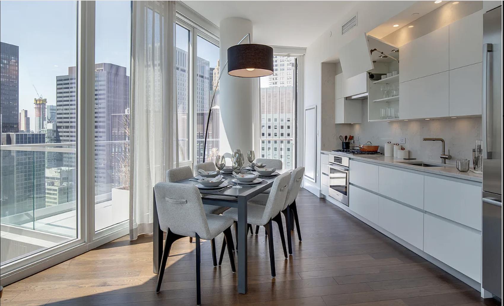 a kitchen with stainless steel appliances a dining table chairs and a large window