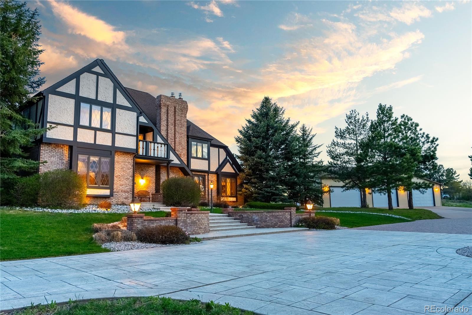 a view of a big house with a big yard and large trees