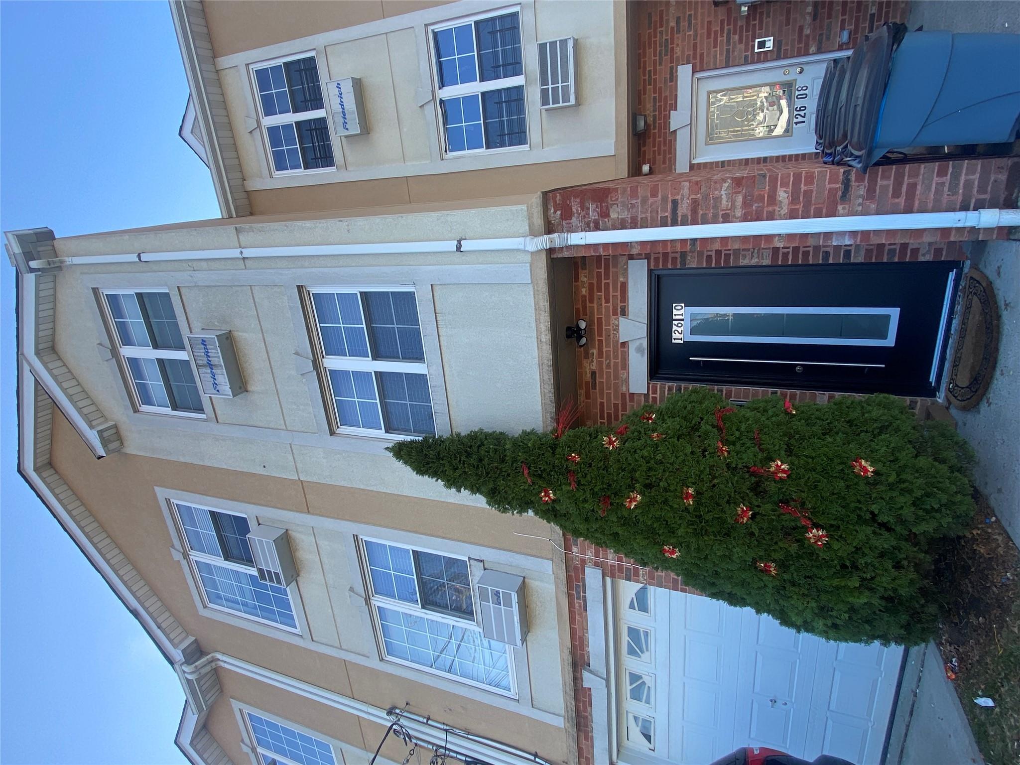 View of front of house with a garage and cooling unit