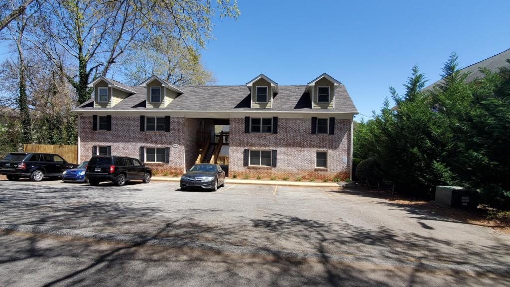 a view of a house with large space and a car park in front of it