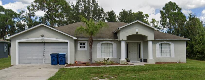 a front view of a house with a yard and trees