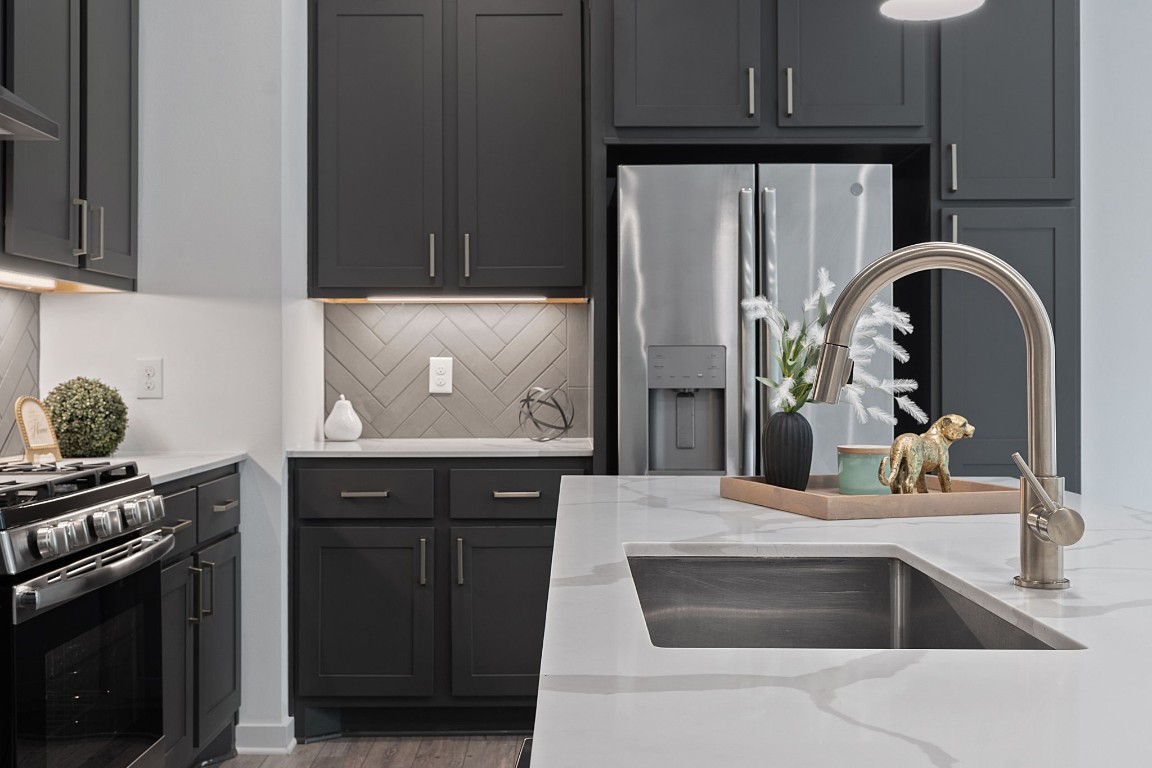 a kitchen with stainless steel appliances granite countertop a stove and a refrigerator with wooden floor