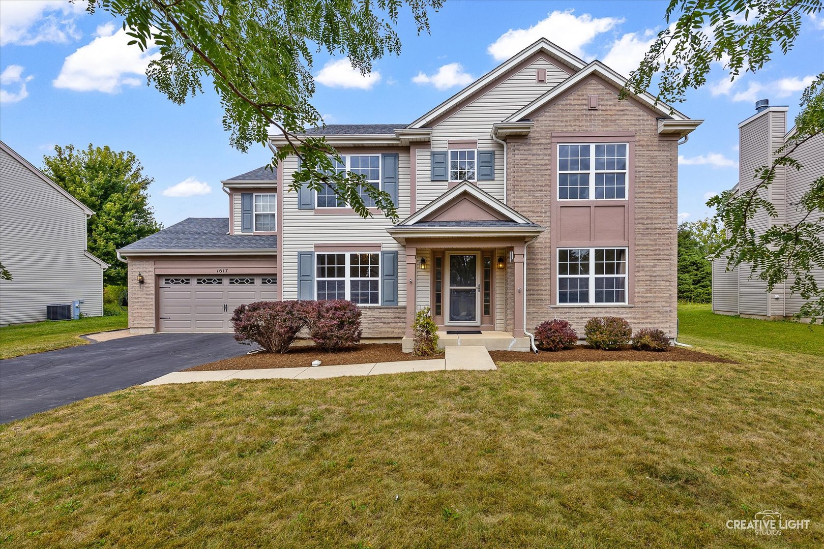 a front view of a house with a yard outdoor seating and garage