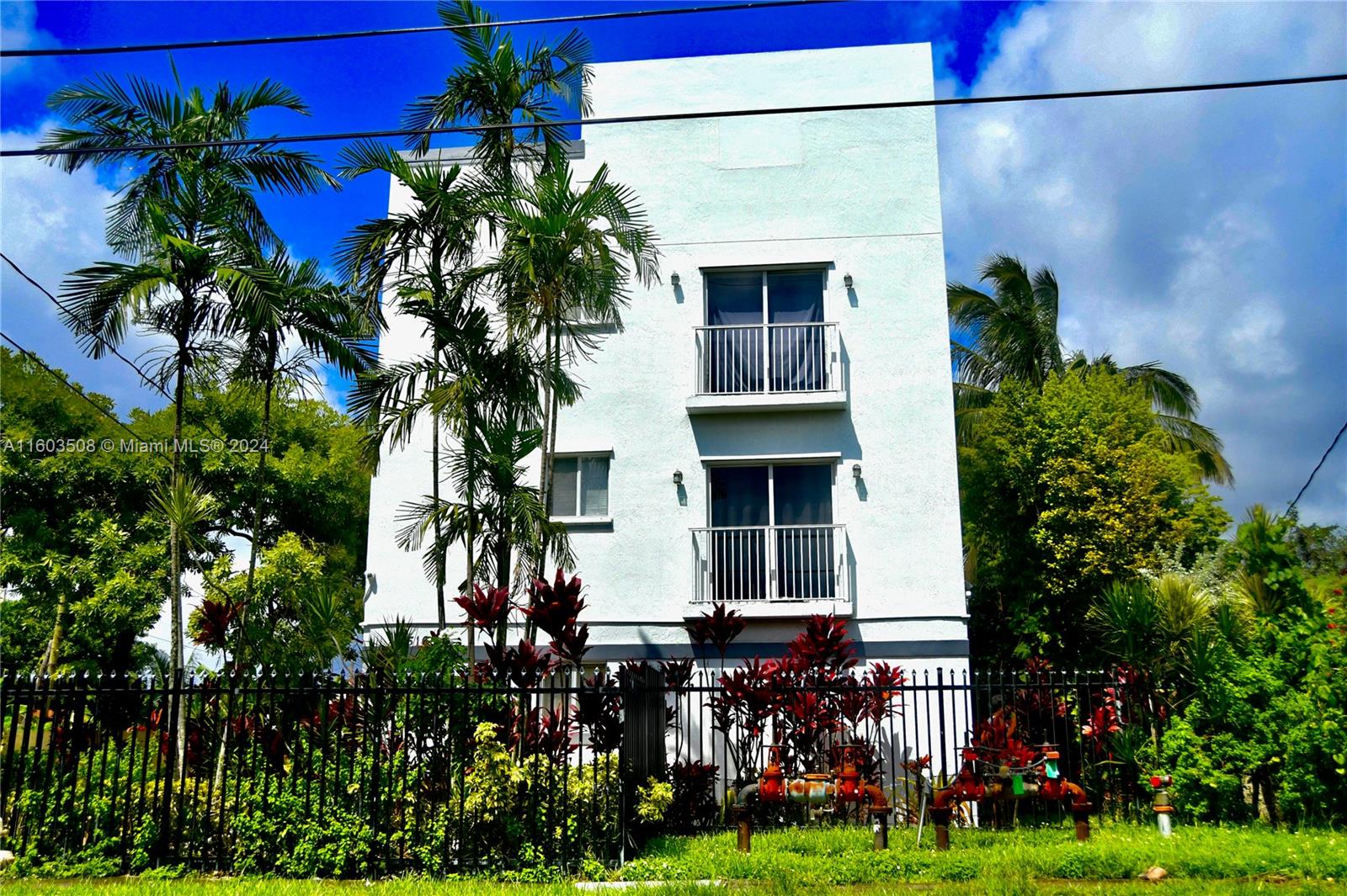 a view of a house with a yard and potted plants