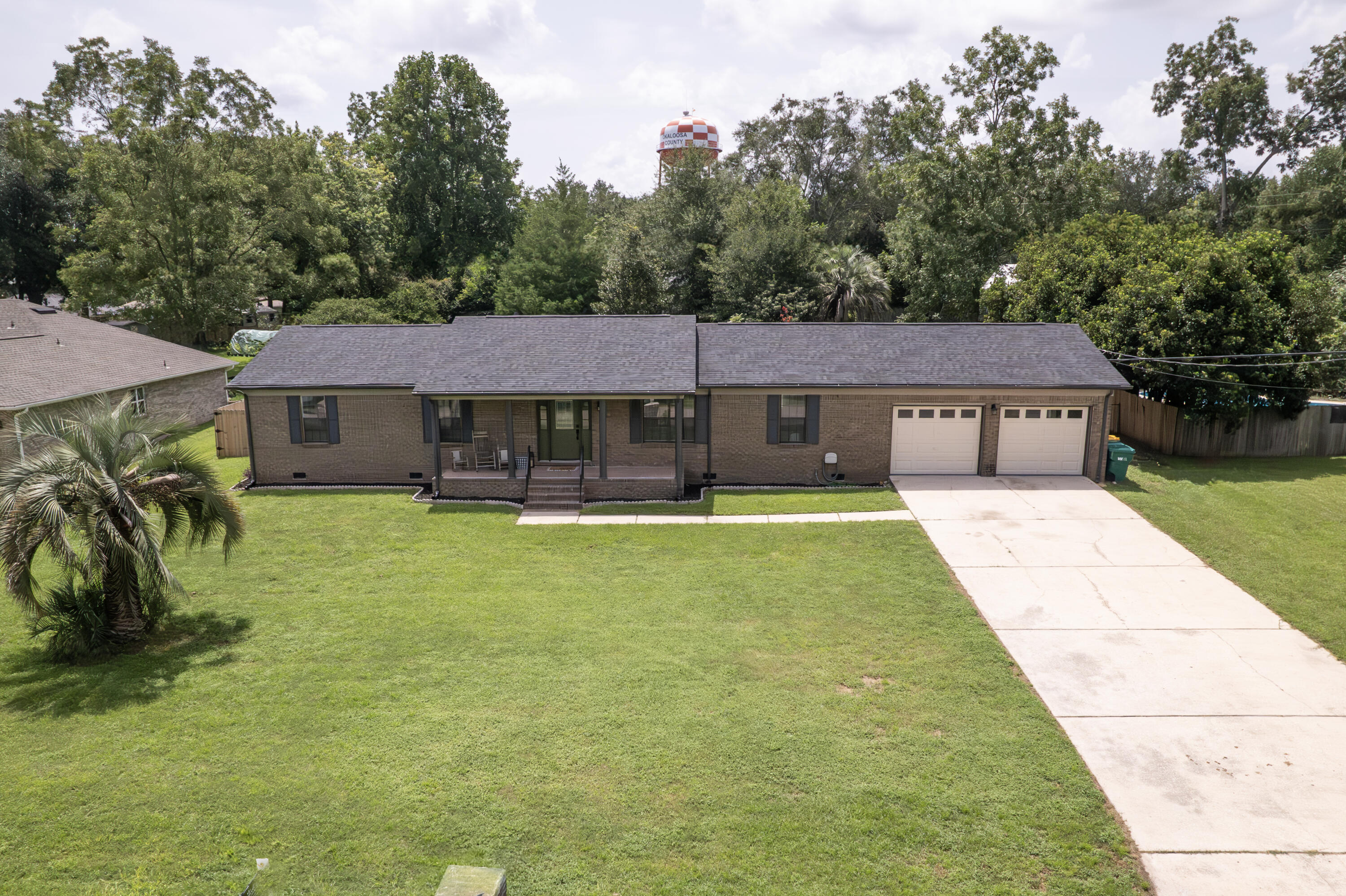 a aerial view of a house with swimming pool and large trees