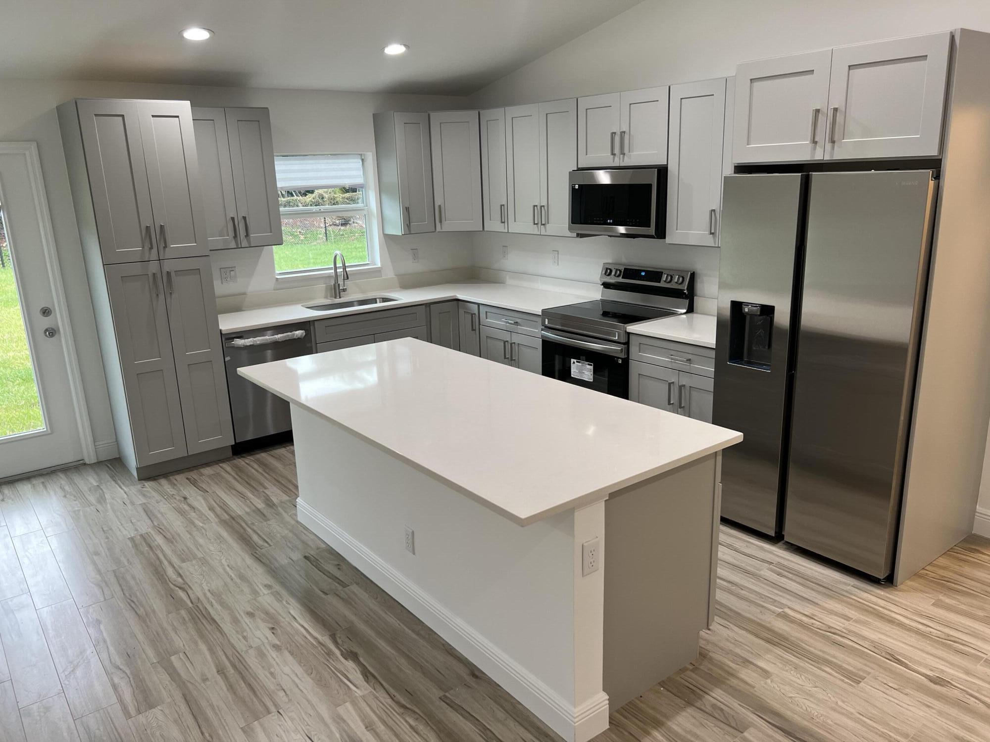 a kitchen with stainless steel appliances a refrigerator sink and microwave