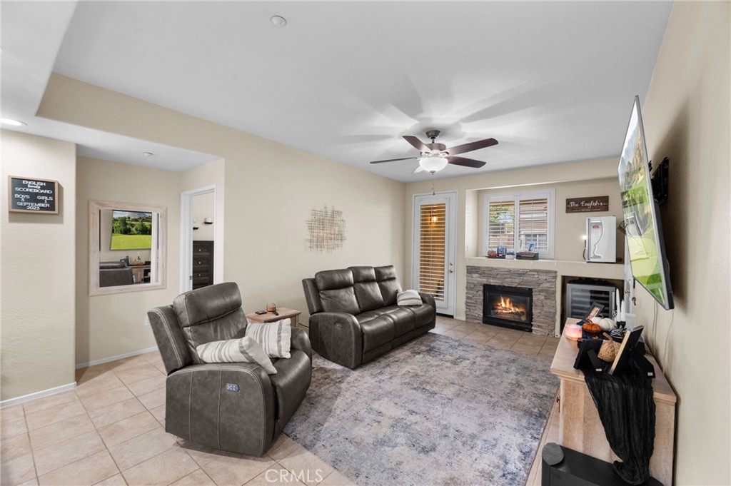 a living room with furniture a flat screen tv and a fireplace