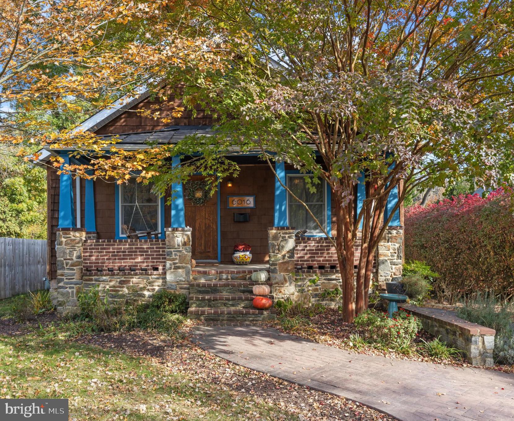 a front view of a house with a tree