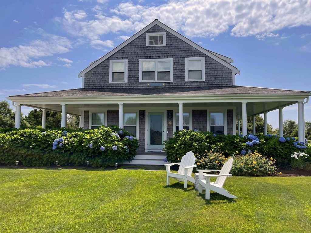 a front view of the house with garden and porch