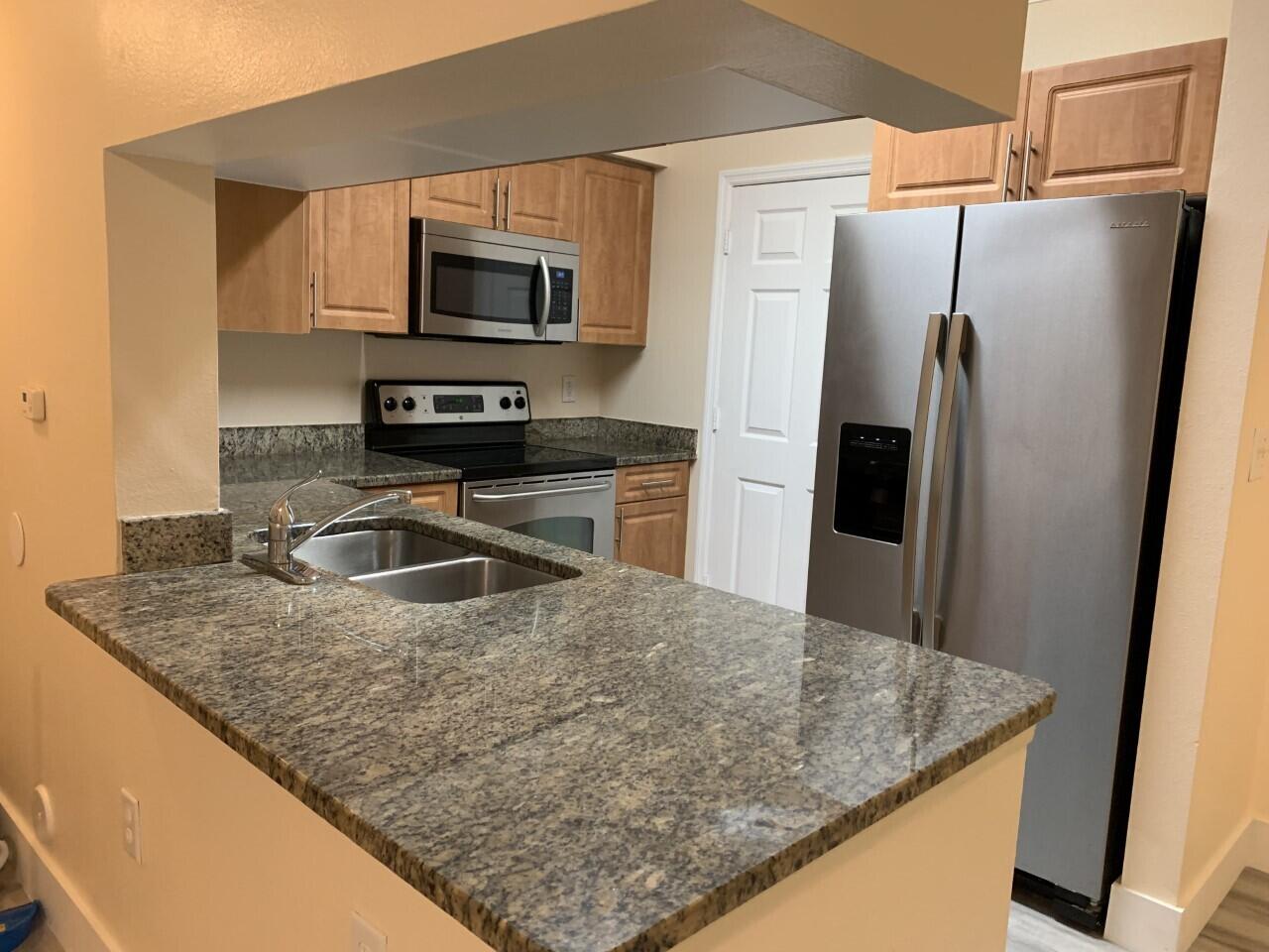 a kitchen with kitchen island a sink stove and refrigerator