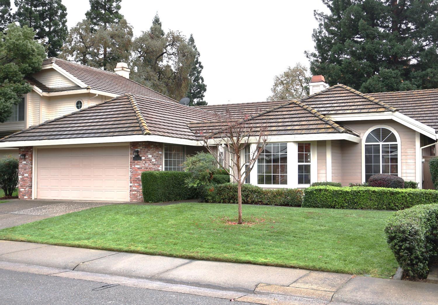 a front view of a house with a yard and potted plants