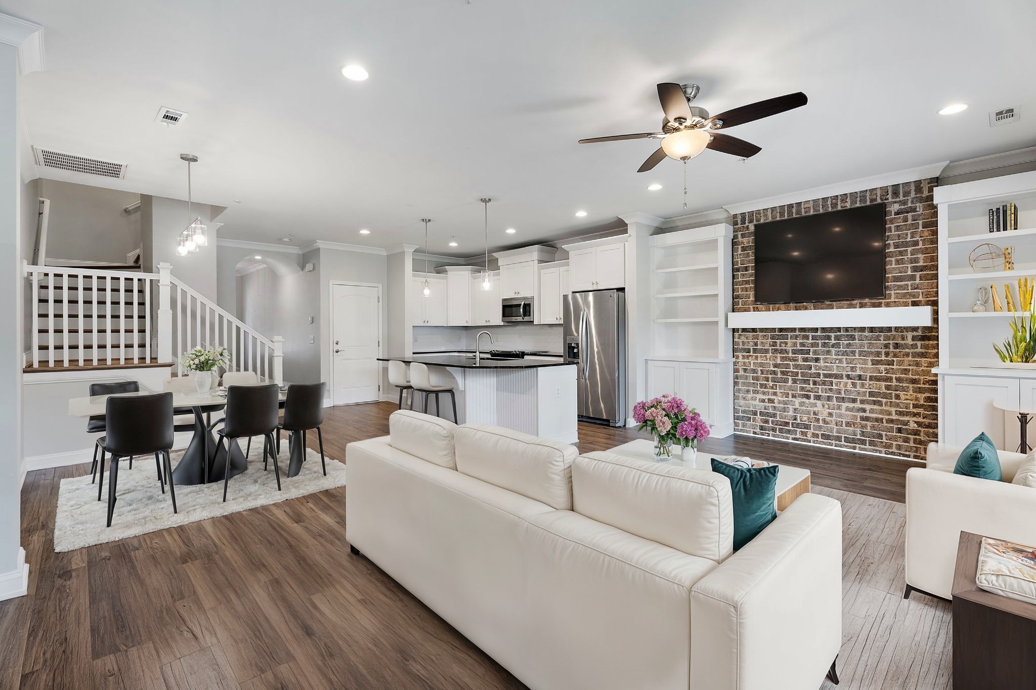 a living room with furniture kitchen and a flat screen tv