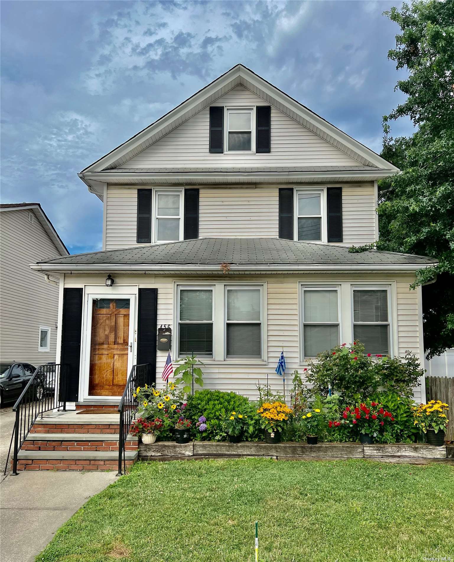 a front view of a house with a garden and plants