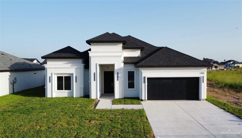 View of front of house featuring a garage and a front lawn