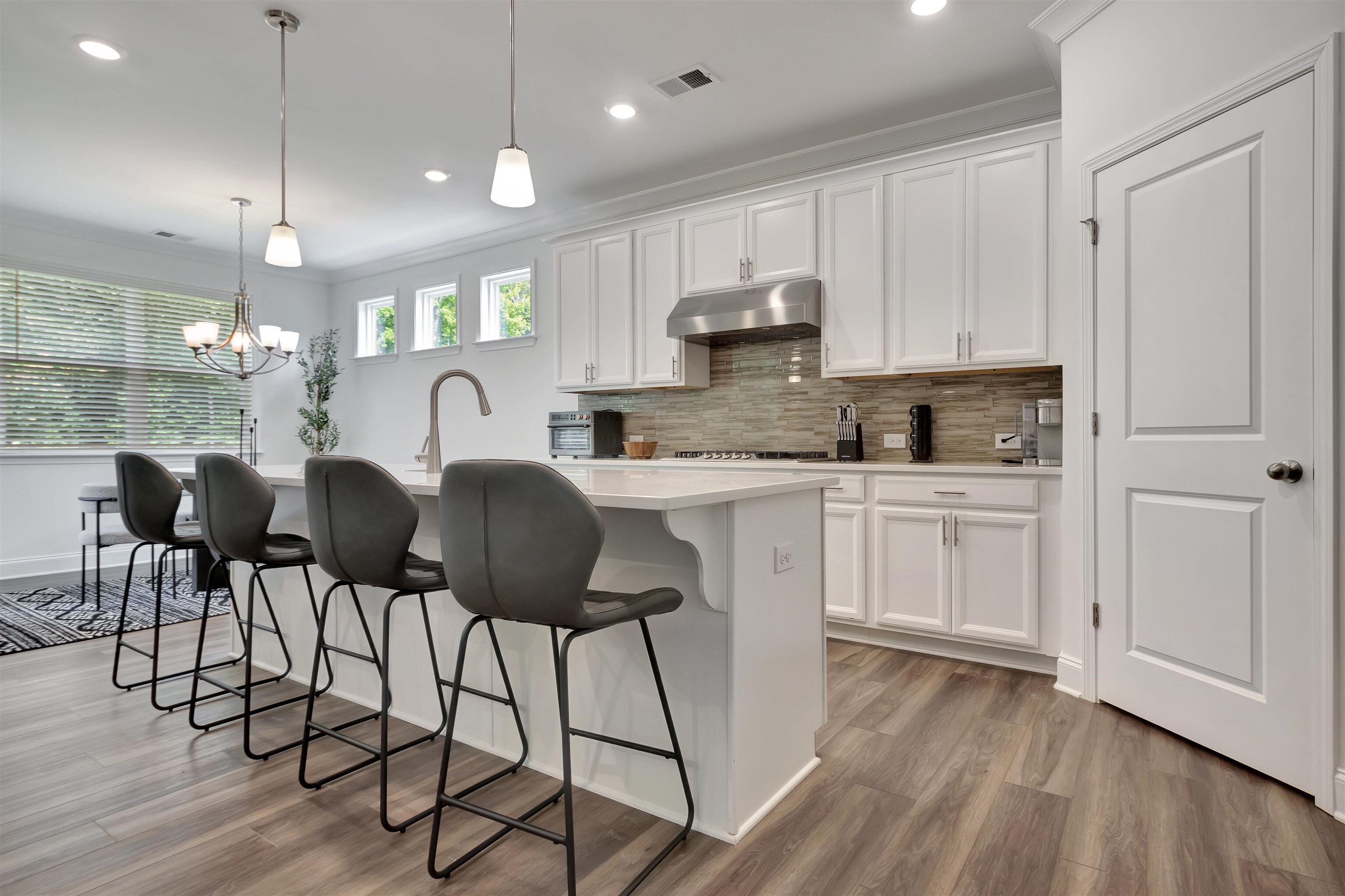 a kitchen with kitchen island granite countertop a sink cabinets and wooden floor