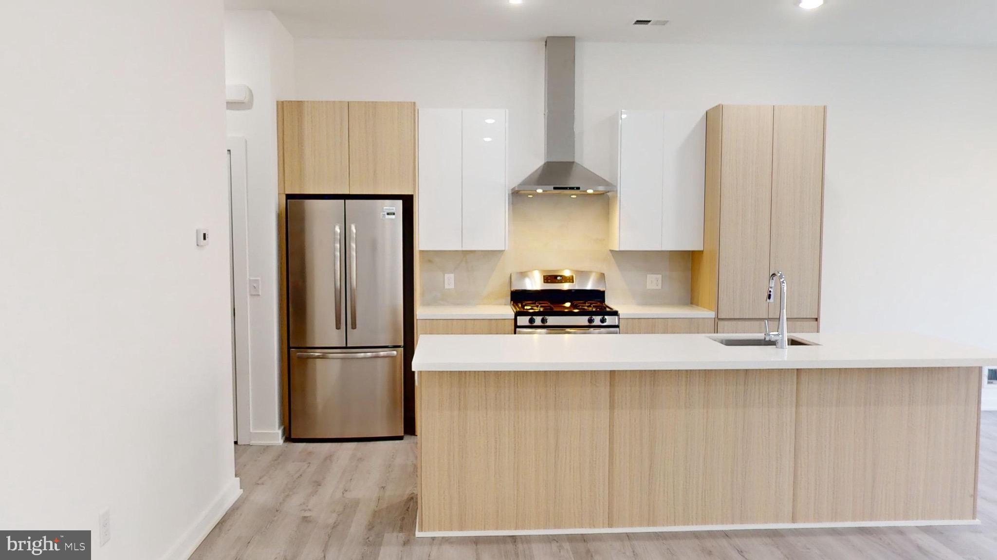 a kitchen with stainless steel appliances a refrigerator and a sink