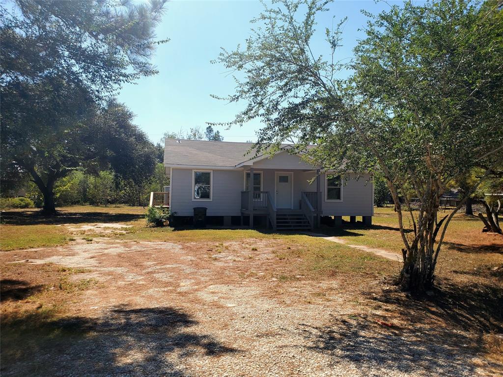 a front view of a house with a yard and trees