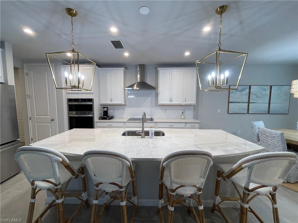 a kitchen with stainless steel appliances kitchen island granite countertop a dining table chairs and sink