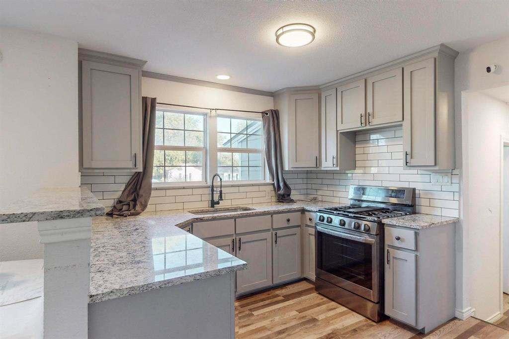 a kitchen with stainless steel appliances granite countertop a sink stove and cabinets