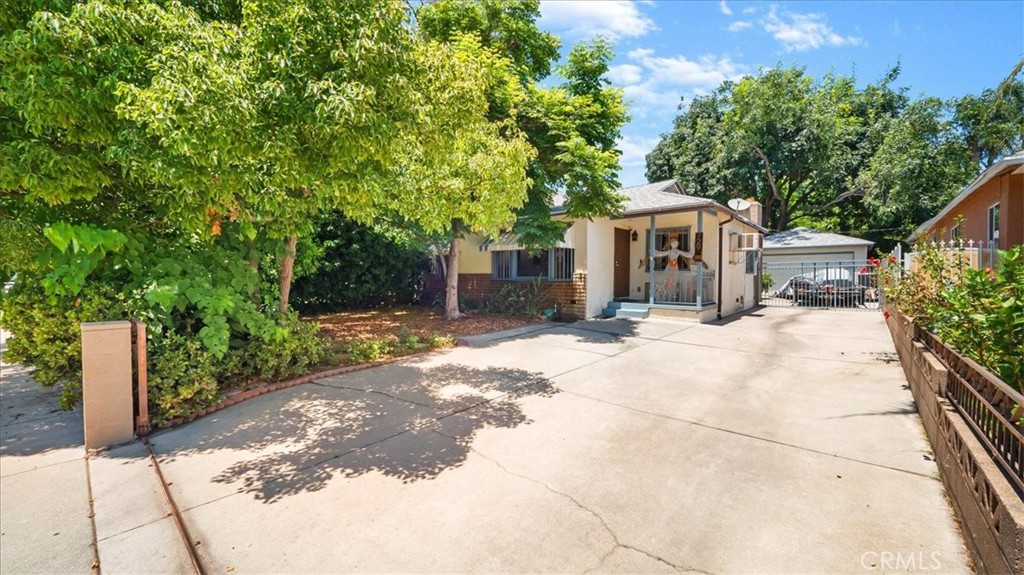 a front view of a house with a yard and potted plants