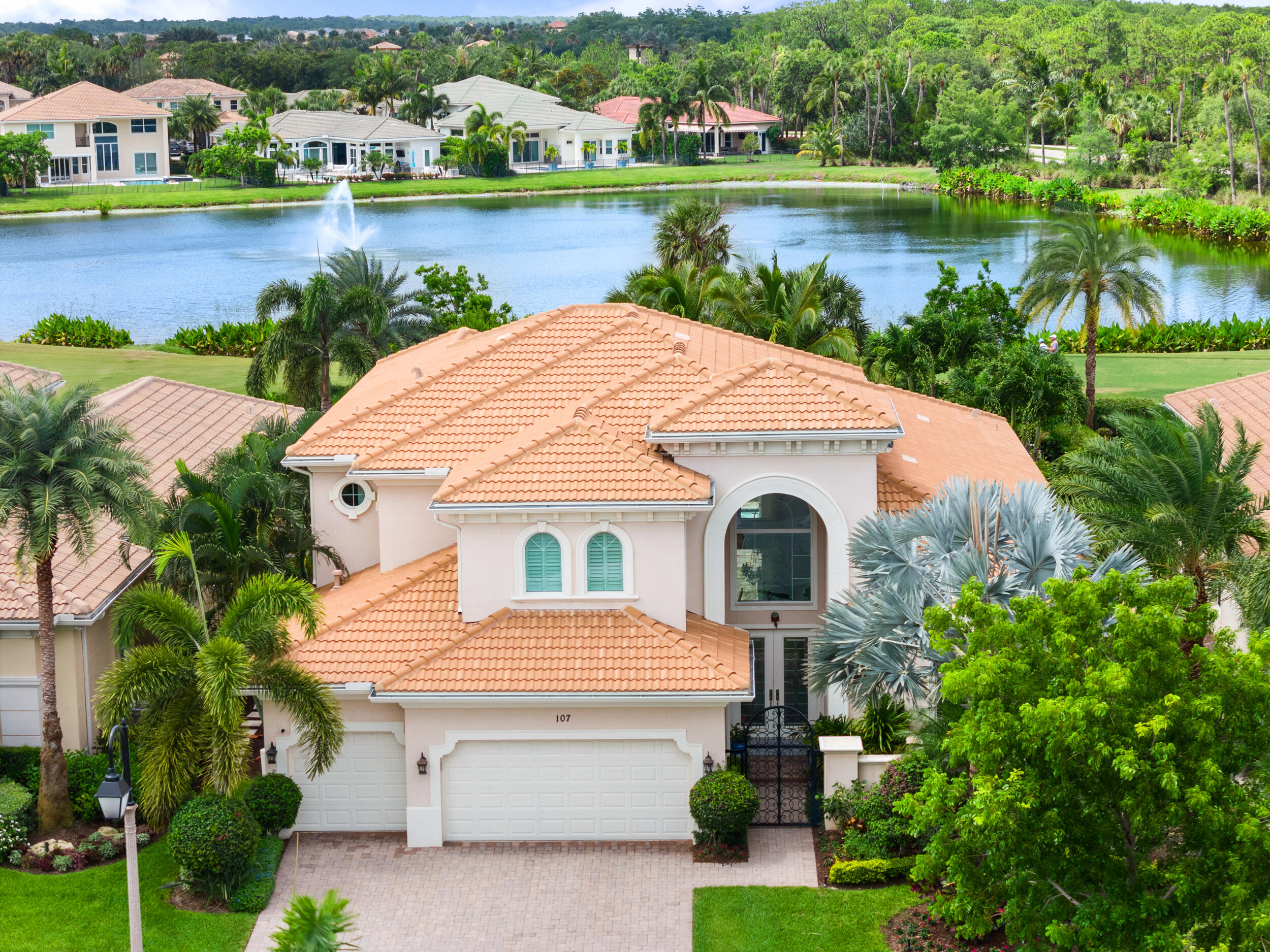 an aerial view of a house with a yard and lake view