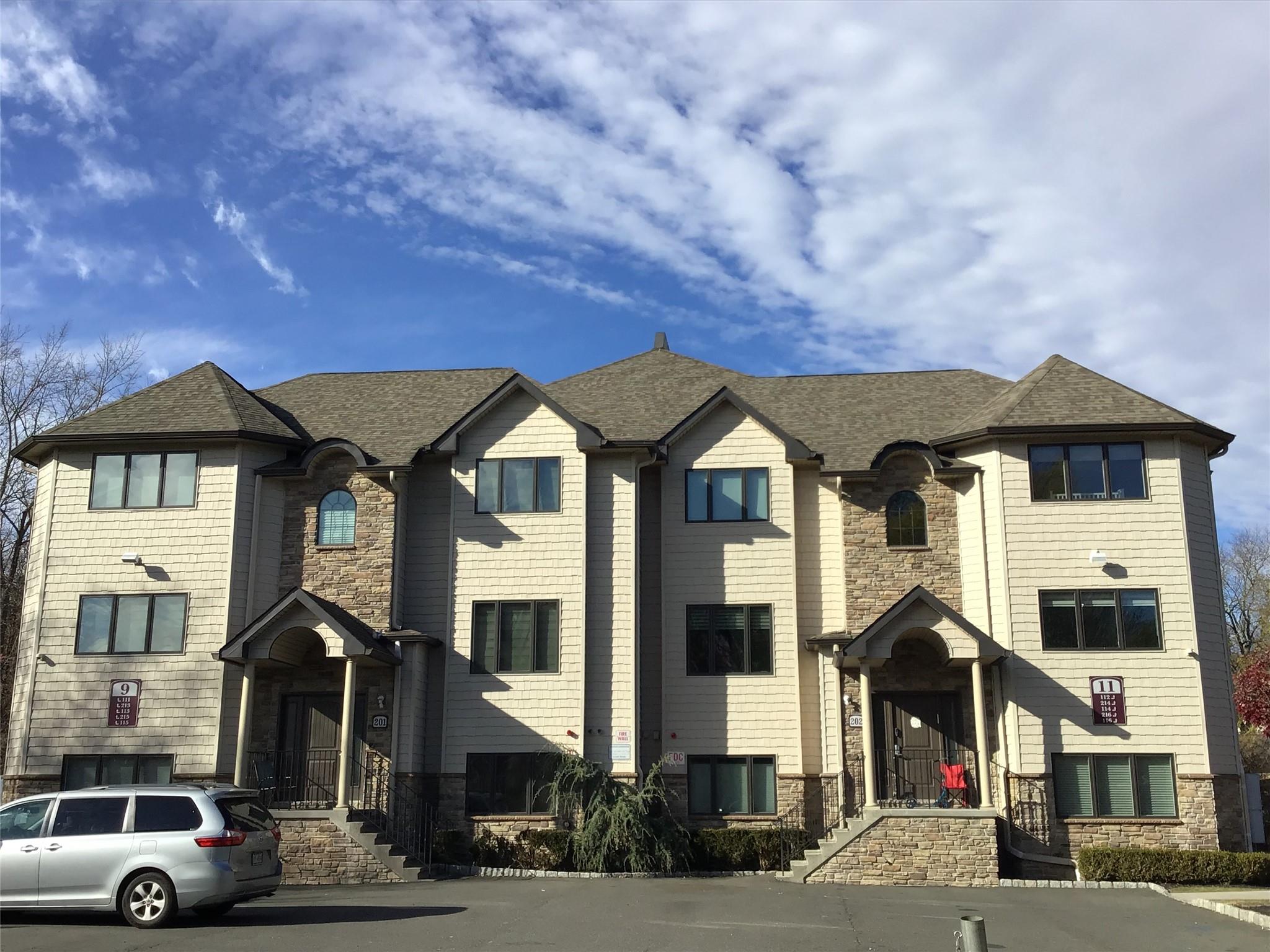 a front view of a residential apartment building with a yard