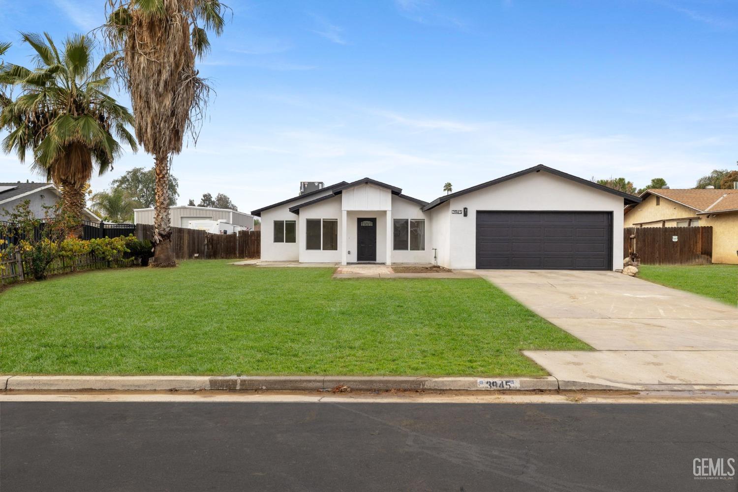 a front view of a house with a garden and yard