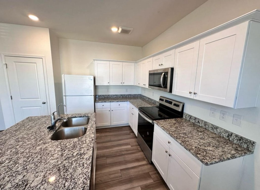 a kitchen with a sink stove and refrigerator