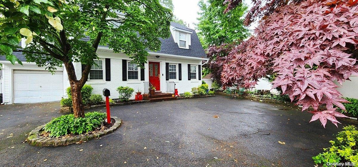 a front view of a house with a yard and potted plants