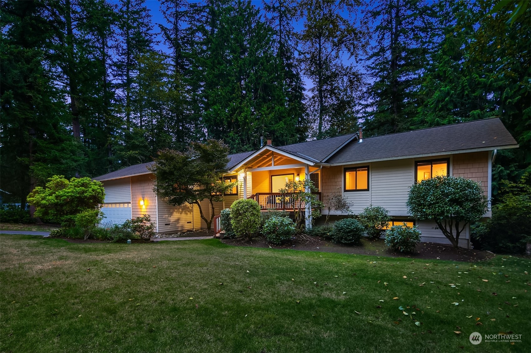 a backyard of a house with plants and large tree