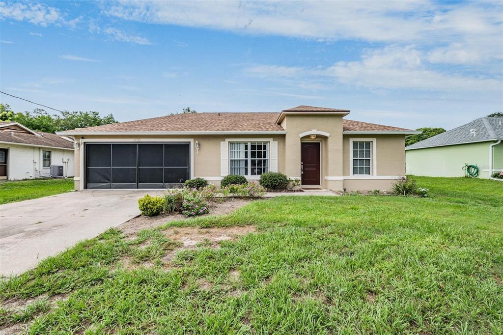 a front view of a house with a yard and garage