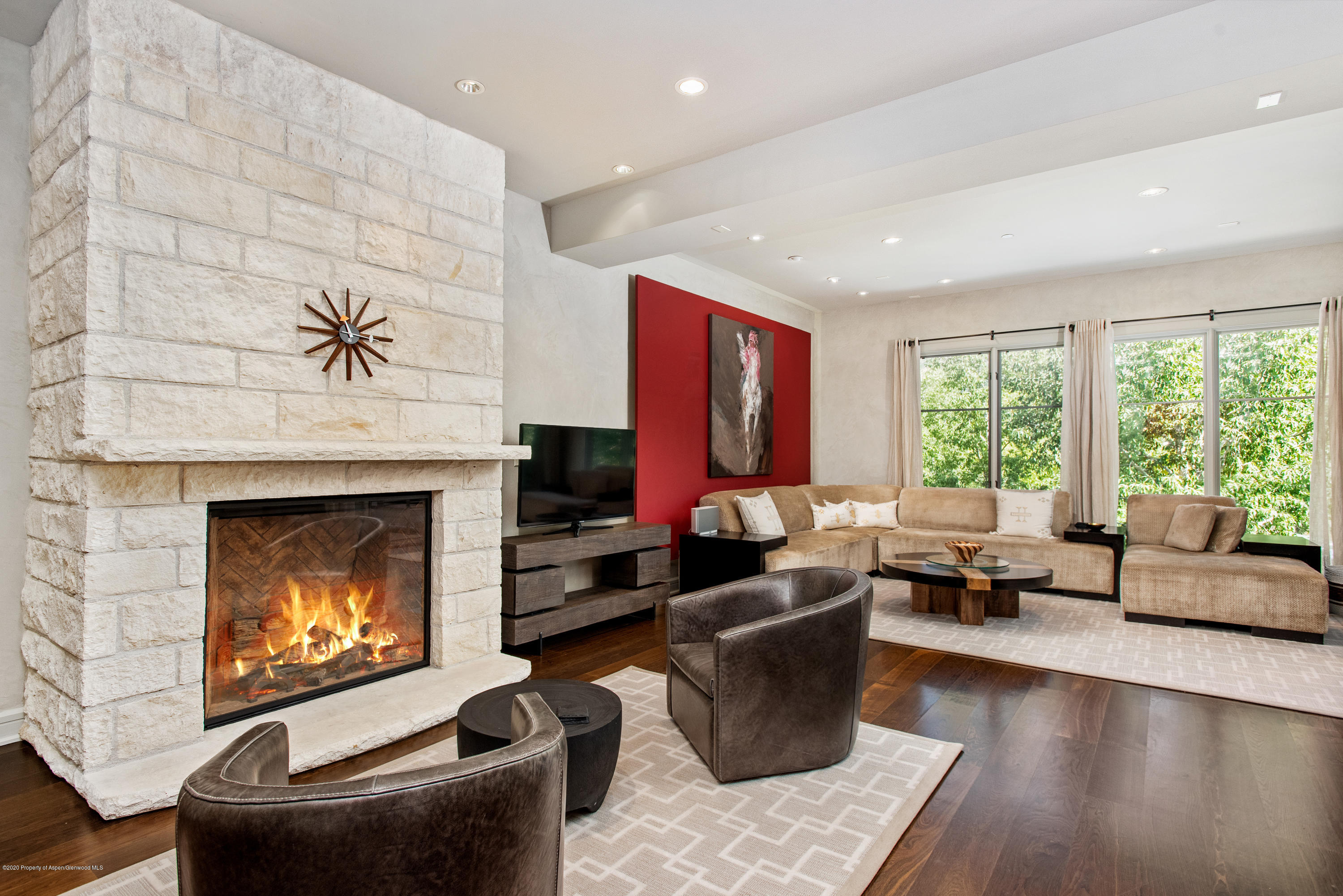 a living room with furniture a fireplace and a floor to ceiling window