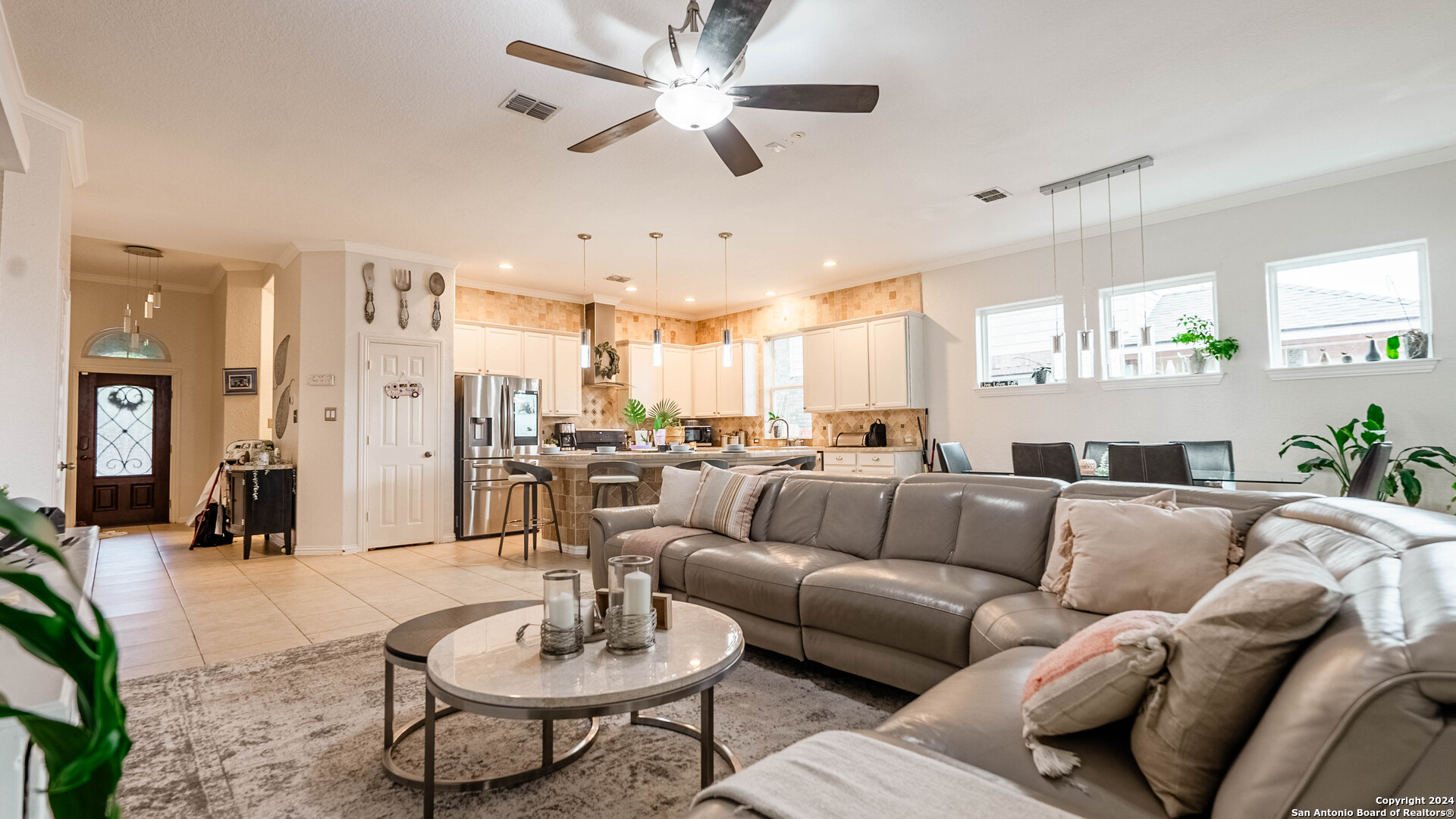 a living room with furniture kitchen view and a chandelier